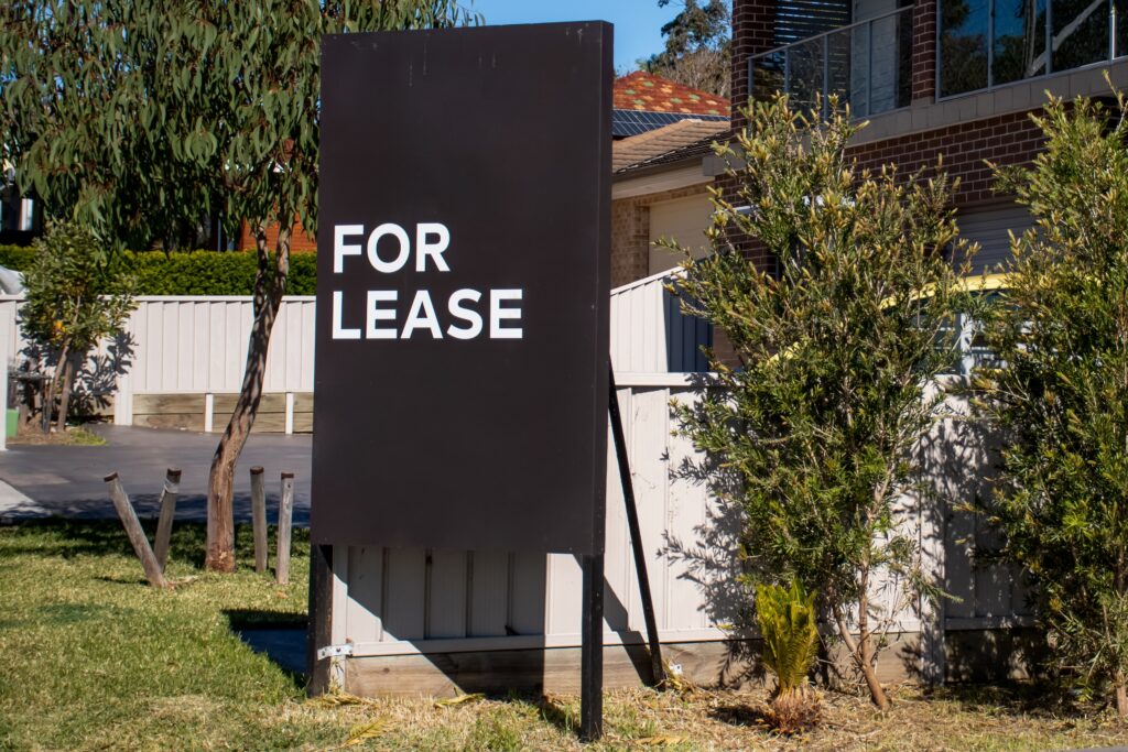 For lease sign near residential building house. Rental property. Leasing. Rent. Real estate